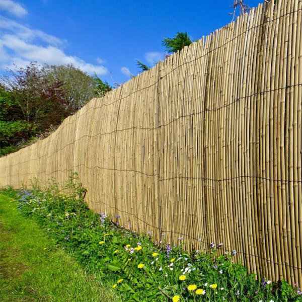 A lot of bamboo slat screens installed by a customer to line a garden boundary