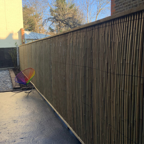 A customer image of the bamboo slat screen installed in a garden using a timber frame