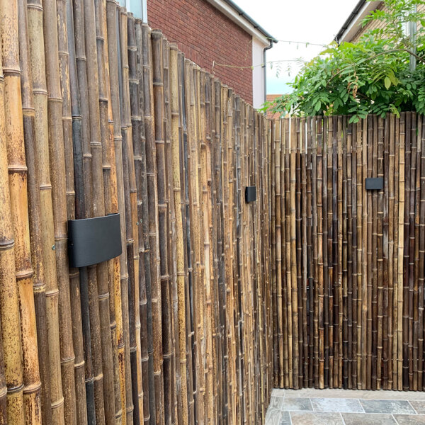 A close-up image of an installed black bamboo screen customised with light fittings