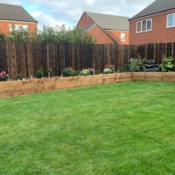 Black bamboo screens surround the boundary of a customer's large garden