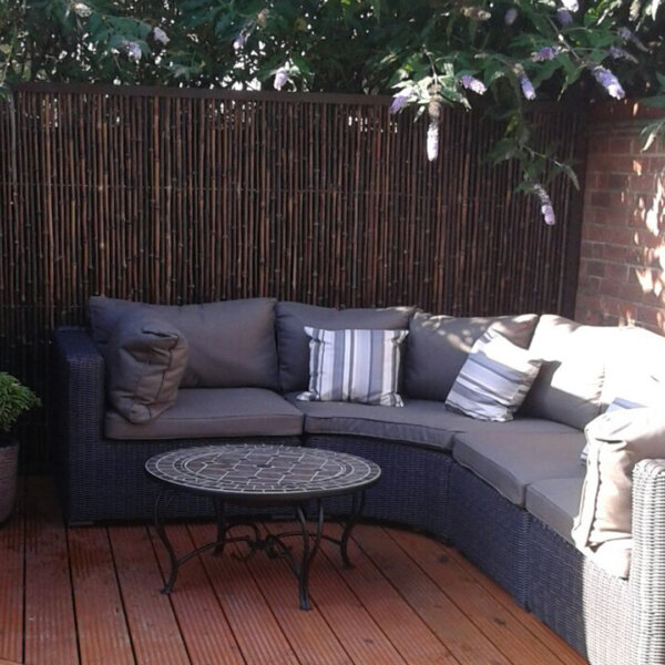 Customer photo of a black bamboo screen installed in an outdoor garden seating area