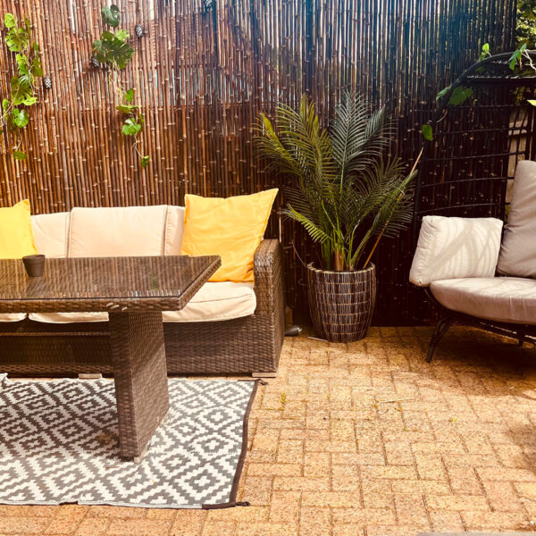 A black bamboo garden screen in a customer's patio area in the summer