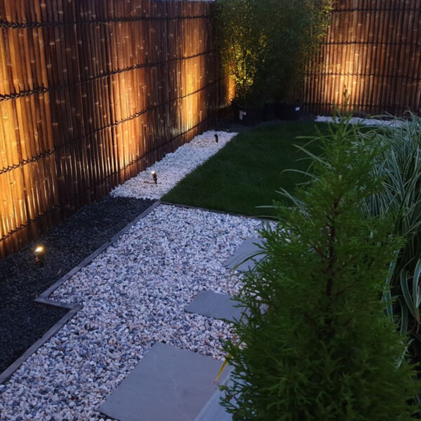 Java Black bamboo half round fence panels in a landscaped garden