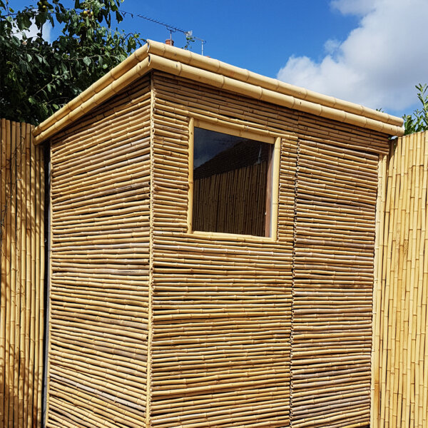 Moso bamboo screens and half round natural poles are used to clad a customer's shed