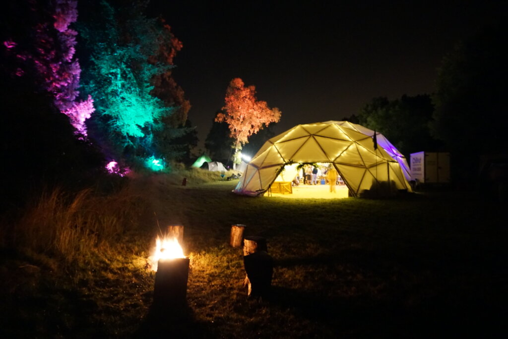 The exterior of a bamboo geodesic dome at night by Atlas Domes