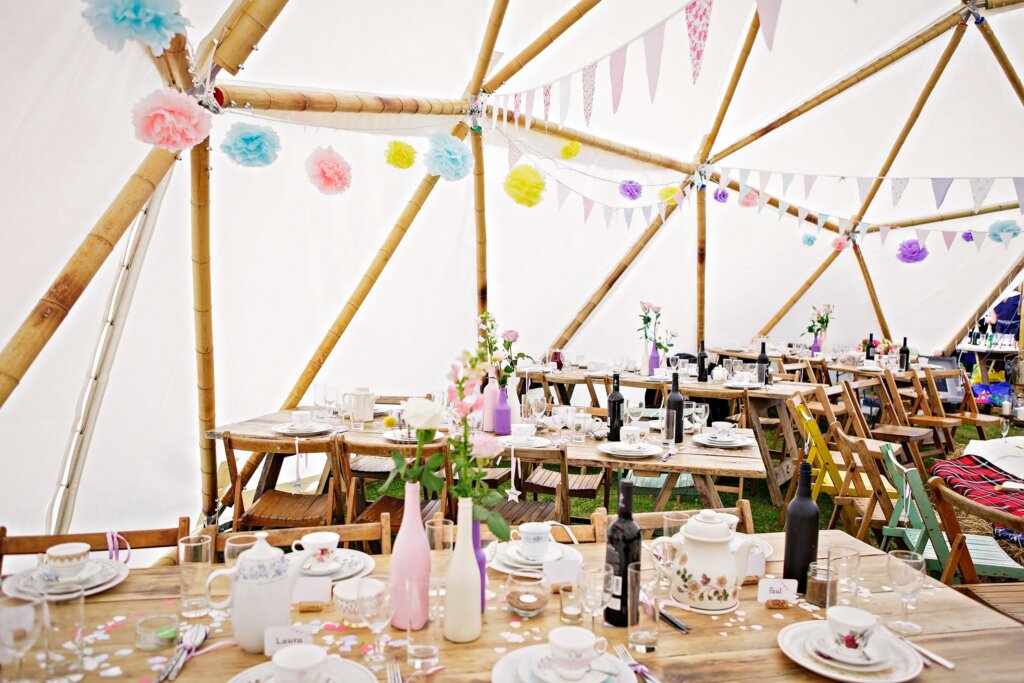A table set out for a party inside a geodesic dome made out of moso bamboo poles