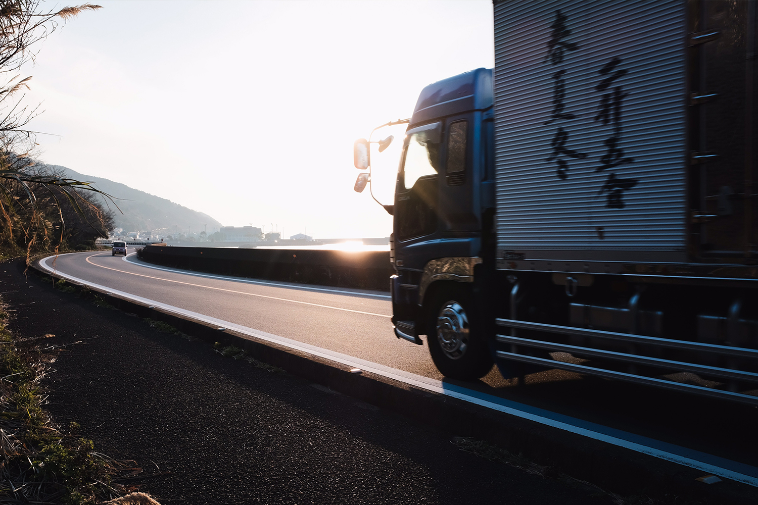 A Chinese delivery lorry on the highway with a sunrise in the background