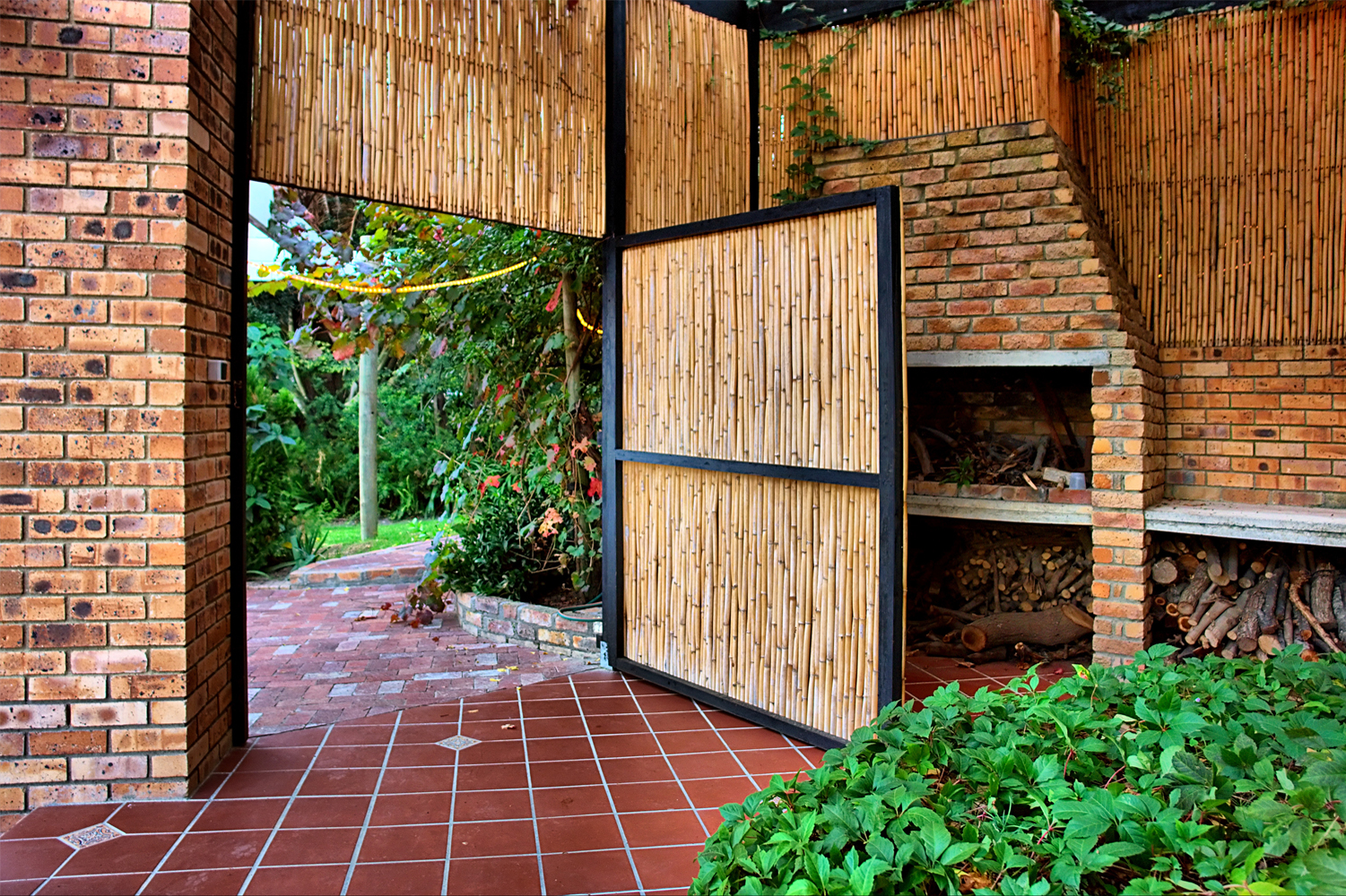 Natural bamboo roll screen installed on walls and a door in a garden room