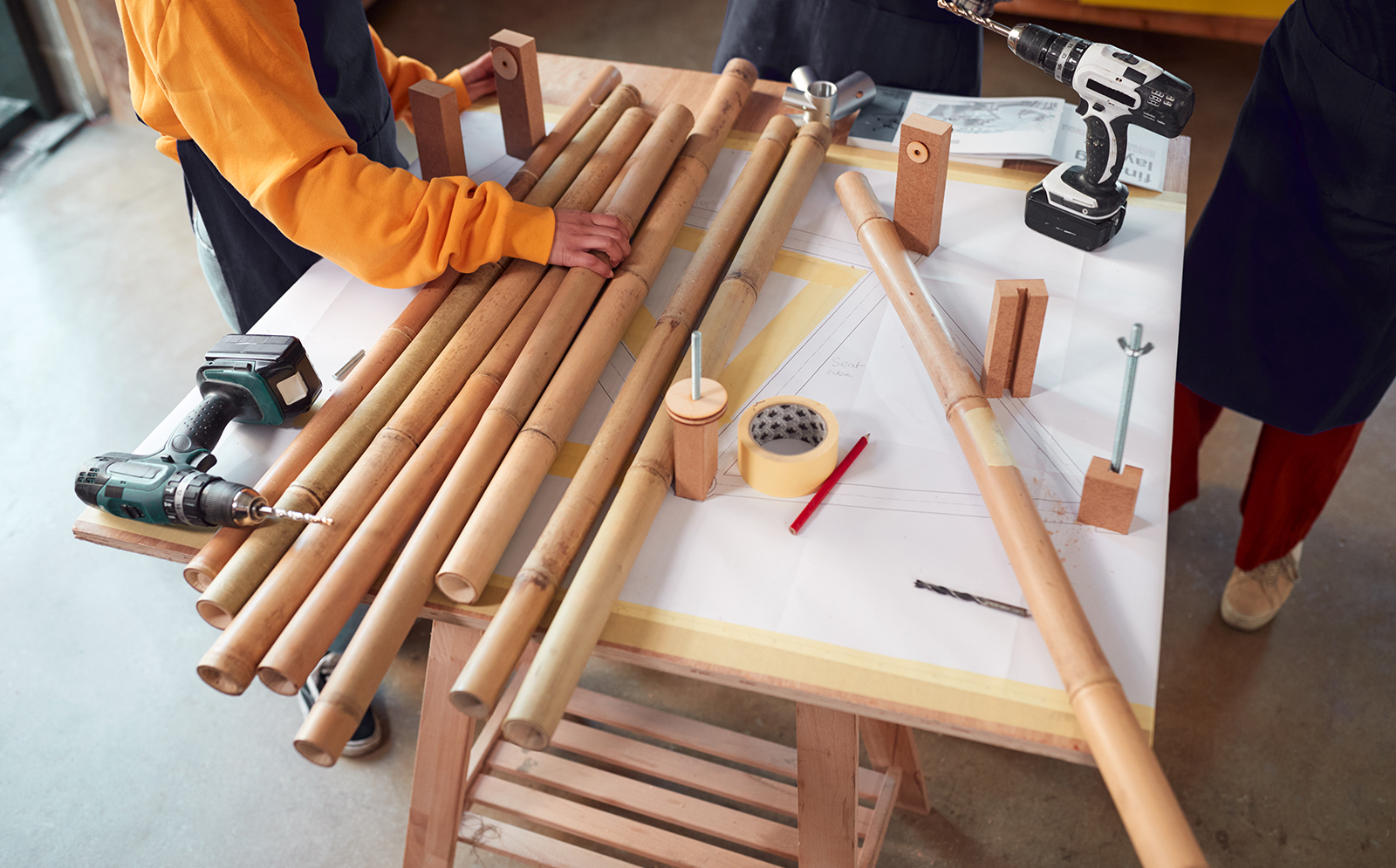 A team working with bamboo poles to make their design project at university