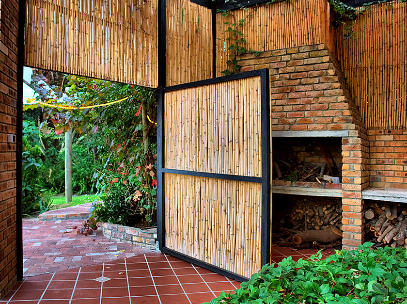 Natural bamboo roll screens used to create a door and edge a garden room