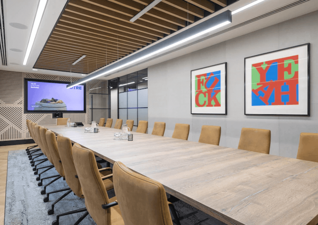 An executive board room with bamboo wall panelling by Genesis Surfaces at the far end.